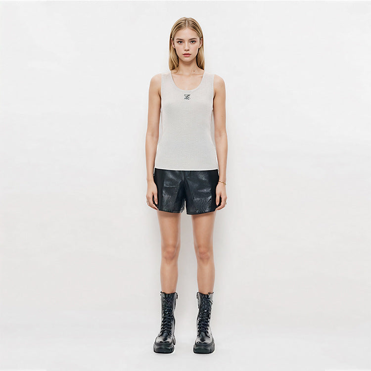 Elegant blouse with a round neckline, sleeveless, and halter neck, made from luxurious embroidered wool knit fabric.