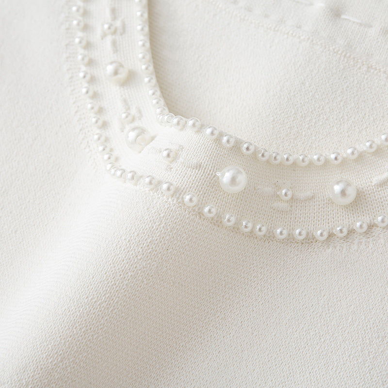 White dress with round neckline, sleeveless, pleated skirt with bead embroidery, high-quality knit fabric