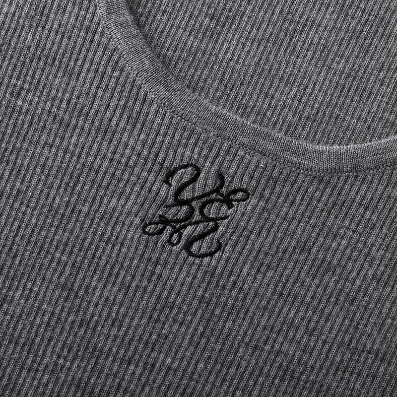 Elegant blouse with a round neckline, sleeveless, and halter neck, made from luxurious embroidered wool knit fabric.