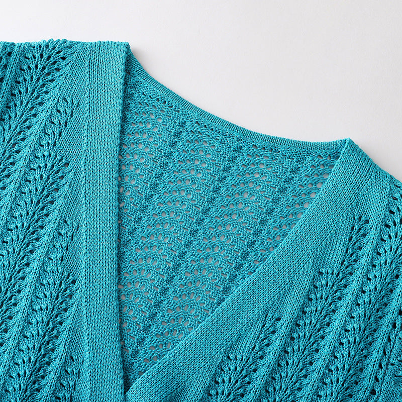 Elegant knit beach dress with blue V-neckline, long sleeves, low waist, and mid-length