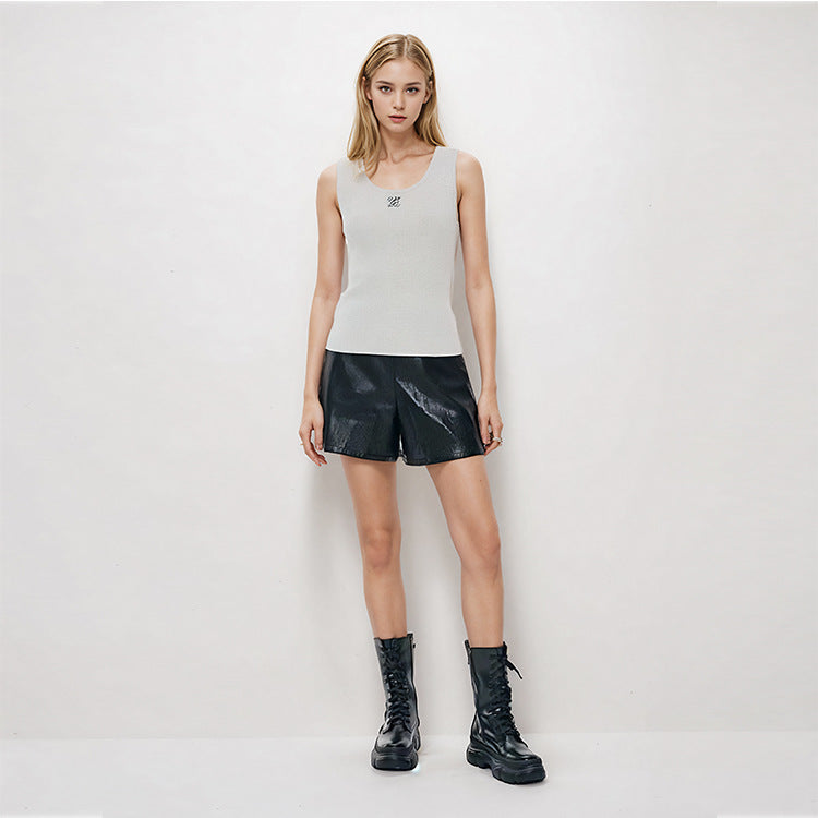 Elegant blouse with a round neckline, sleeveless, and halter neck, made from luxurious embroidered wool knit fabric.