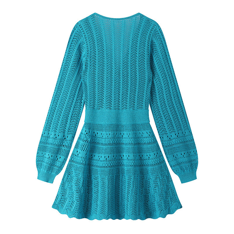 Elegant knit beach dress with blue V-neckline, long sleeves, low waist, and mid-length