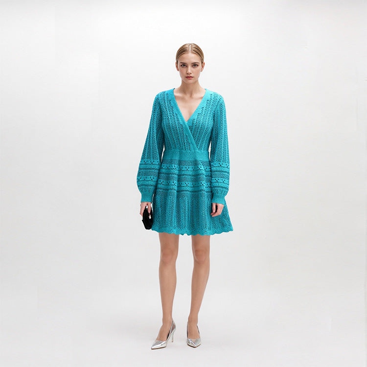 Elegant knit beach dress with blue V-neckline, long sleeves, low waist, and mid-length