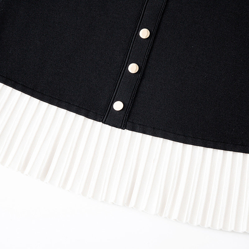 Elegant black and white French-style dress with contrasting round neckline, short sleeves, buttons, and high-quality pleats