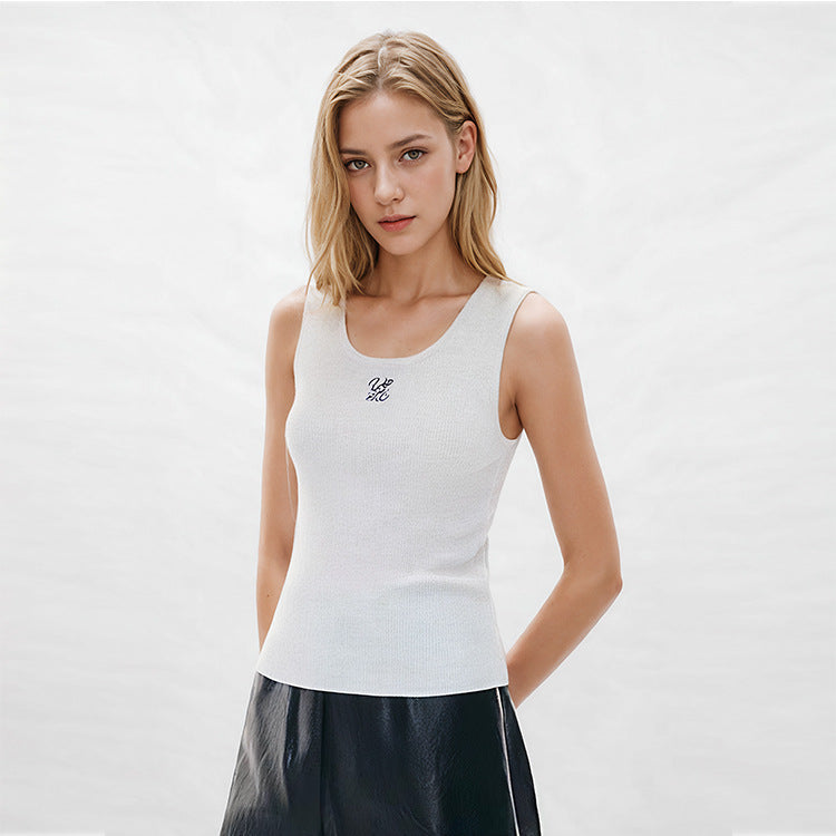 Elegant blouse with a round neckline, sleeveless, and halter neck, made from luxurious embroidered wool knit fabric.