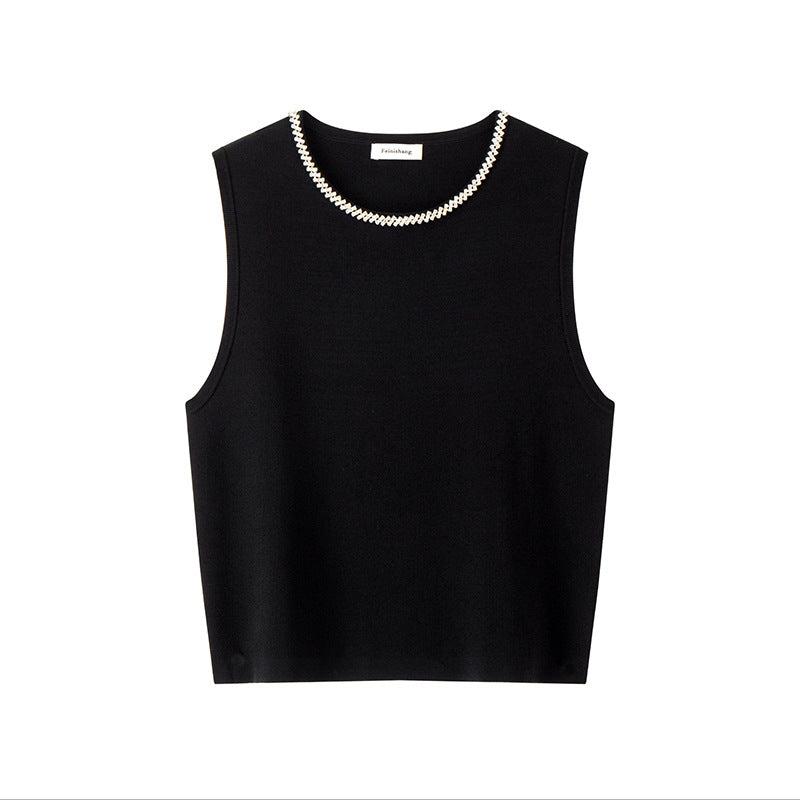 Elegant set consisting of a black sleeveless blouse with a round neckline and studs, paired with a high-waisted skirt with high-quality knit lacing
