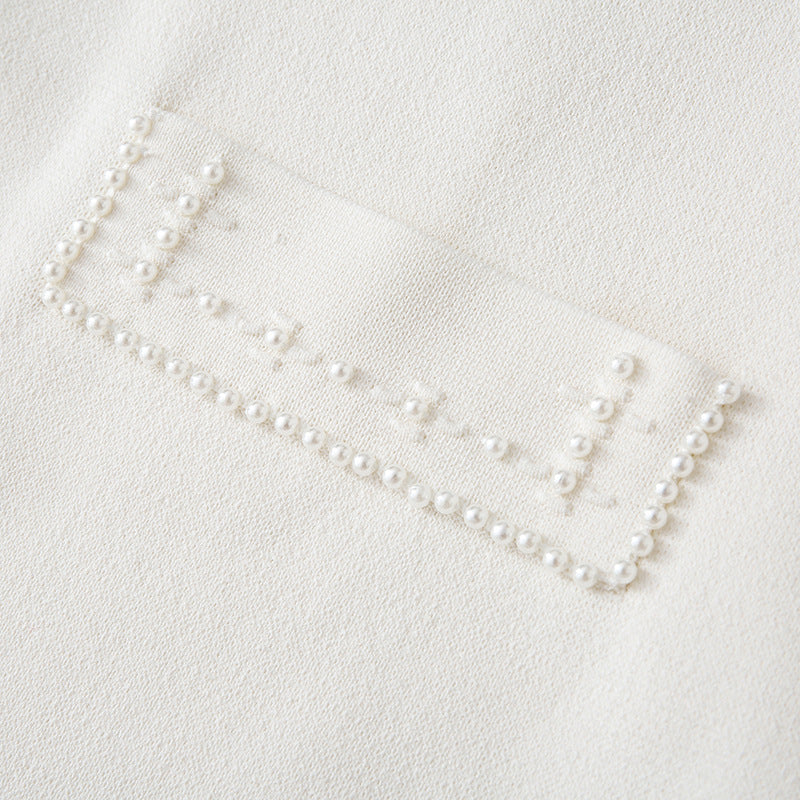 White dress with round neckline, sleeveless, pleated skirt with bead embroidery, high-quality knit fabric